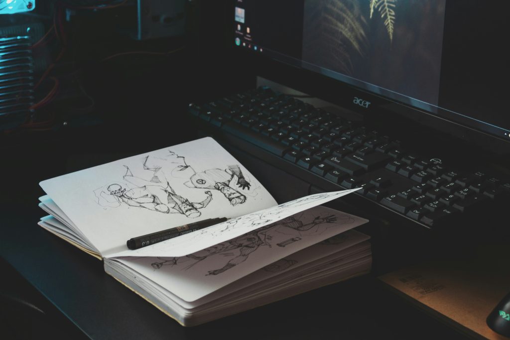 A notebook, a pen and a laptop