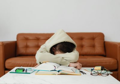 Boredom: A Greater threat to Success than Failure A woman is sleeping on a table; with her books