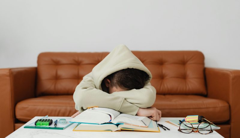 Boredom: A Greater threat to Success than Failure A woman is sleeping on a table; with her books
