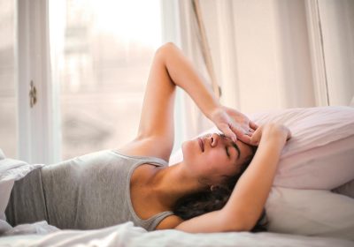 A woman waking up with hands on her head