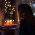 A woman blowing cake candles